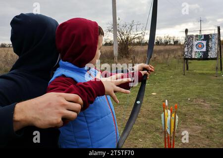 Zaporizhzhia, Ucraina. 5 novembre 2023. Un ragazzino ha visto praticare il tiro con l'arco con suo padre nel club di tiro con l'arco dei cosacchi "Bayda". La guerra tra Israele e Gaza sta "togliendo l'attenzione” dal conflitto in Ucraina, ha ammesso il presidente del paese Volodymyr Zelensky. E ha negato che i combattimenti in Ucraina avessero raggiunto uno stallo, nonostante una recente valutazione in tal senso da parte del generale militare più importante del paese. La controffensiva dell'Ucraina nel sud ha finora fatto pochi progressi. Credito: SOPA Images Limited/Alamy Live News Foto Stock