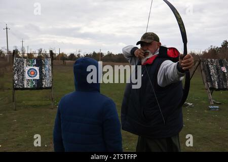 Zaporizhzhia, Ucraina. 5 novembre 2023. Un giovane ragazzo ascolta l'allenatore durante la pratica di tiro con l'arco nel club di tiro con l'arco dei cosacchi "Bayda". La guerra tra Israele e Gaza sta "togliendo l'attenzione” dal conflitto in Ucraina, ha ammesso il presidente del paese Volodymyr Zelensky. E ha negato che i combattimenti in Ucraina avessero raggiunto uno stallo, nonostante una recente valutazione in tal senso da parte del generale militare più importante del paese. La controffensiva dell'Ucraina nel sud ha finora fatto pochi progressi. (Foto di Andriy Andriyenko/SOPA Images/Sipa USA) credito: SIPA USA/Alamy Live News Foto Stock