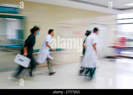 Gli operatori sanitari si sono precipitati oltre la sala di trattamento di emergenza, primo piano della foto Foto Stock