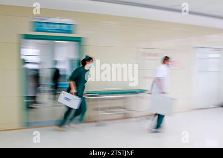 Gli operatori sanitari si sono precipitati oltre la sala di trattamento di emergenza, primo piano della foto Foto Stock