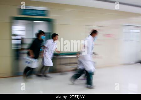 Gli operatori sanitari si sono precipitati oltre la sala di trattamento di emergenza, primo piano della foto Foto Stock