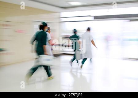 Gli operatori sanitari si sono precipitati oltre la sala di trattamento di emergenza, primo piano della foto Foto Stock