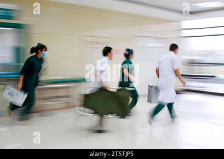 Gli operatori sanitari si sono precipitati oltre la sala di trattamento di emergenza, primo piano della foto Foto Stock