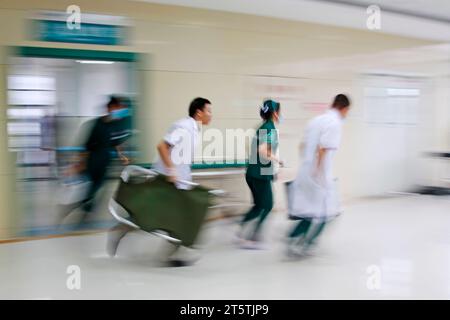 Gli operatori sanitari si sono precipitati oltre la sala di trattamento di emergenza, primo piano della foto Foto Stock