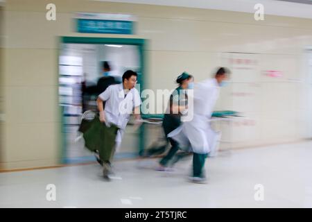 Gli operatori sanitari si sono precipitati oltre la sala di trattamento di emergenza, primo piano della foto Foto Stock