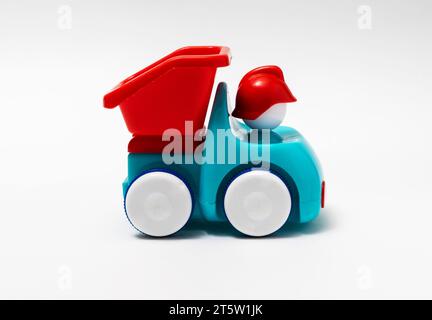 camion per bambini in plastica rosso e blu su sfondo bianco Foto Stock