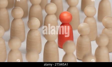 Concetto di discriminazione e inclusione. Le statuette di legno circondano il rendering rosso.3D su sfondo bianco. Foto Stock