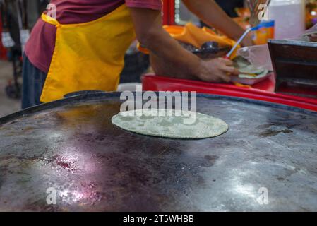 Persona che prepara la tortilla di mais in una bancarella di Street food. Foto Stock