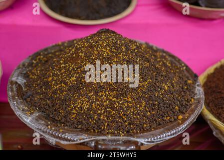 Contenitore con polvere mole. Tipico cibo messicano venduto in un mercato di strada. Foto Stock