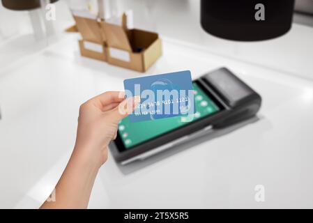 Pagamento sicuro con carta presso l'elegante terminale POS. Carta di credito con custodia per transazione. Procedura di pagamento sicura e comoda Foto Stock