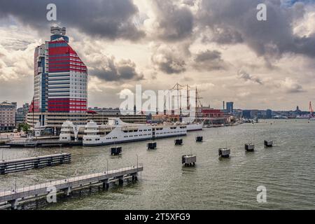 L'edificio blu e rosso che ospita il centro conferenze Lilla Bommen. Sullo sfondo la nave a vela Barken Viking. Gothenburg, Svezia Foto Stock