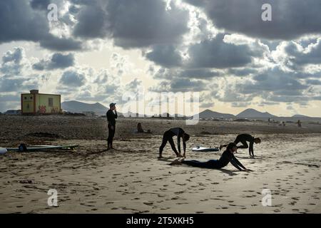 Spagna, Lanzarote, Caleta de Famara: I surfisti si allenano sulla spiaggia di Famara prima di fare surf Foto Stock