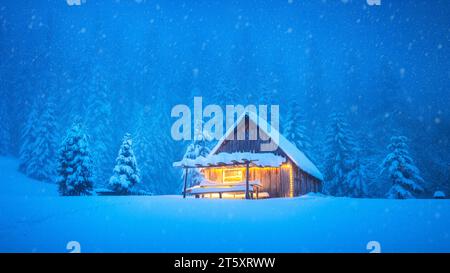 Uno chalet di legno che si trova da solo nel mezzo di una radura di montagna innevata all'interno delle profondità della foresta durante la stagione invernale. Cartolina di Natale. Foresta di montagne innevate Foto Stock