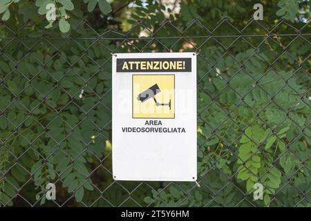 Segnale della telecamera di sicurezza CCTV su una recinzione a catena in un parco Foto Stock