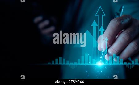 Negoziazione di azioni. Finanza. Investimenti. Business in crescita. Uomo d'affari in completo che punta la penna verso candelabri e frecce su sfondo scuro Foto Stock