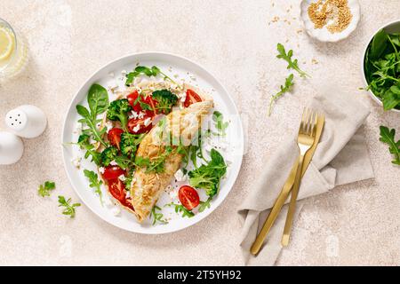 Omelette ripiene di pomodoro, broccoli, feta e foglie verdi fresche di rucola e spinaci. Alimentazione sana, colazione. Vista dall'alto Foto Stock