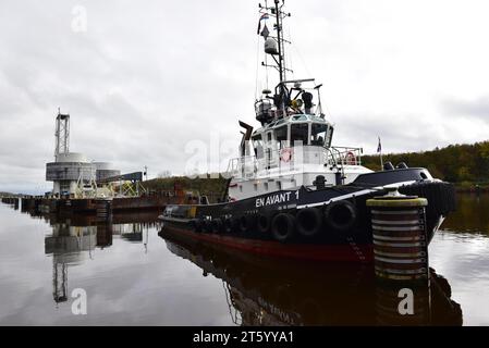 Rimorchiatore che traina un pontone con installazione offshore nel canale di Kiel, Schleswig-Holstein, Germania Foto Stock