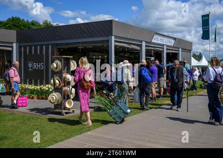 Visitors Passing Hub & Shop (People by Information Center entry & Exhibits, Sunny Showground) - 2023 Flower Show Tatton Park, Cheshire, Inghilterra Regno Unito. Foto Stock