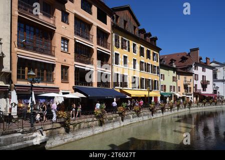 I turisti camminano lungo Quay, Quayside, Quai Perrière o Walkway lungo il fiume le Thiou nel centro storico di Annecy, alta Savoia, Francia Foto Stock