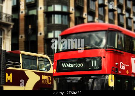 Autobus a due piani rosso di Londra con Waterloo 11 scritto davanti accanto a un Big Bus che va nella direzione opposta. Concetto di trasporto degli autobus di Londra Foto Stock