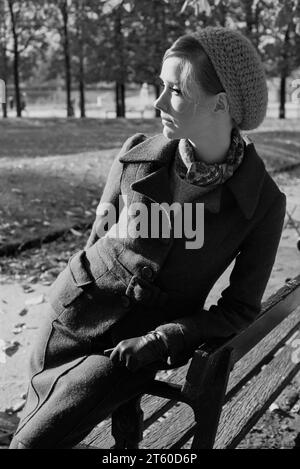 Anni '1960, modella donna appoggiata su una panchina, giardino Jardin des Tuileries, Parigi, Francia, Europa, Foto Stock