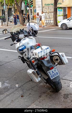 Salonicco, Grecia - 22 ottobre 2023: Motocicletta della polizia greca completamente attrezzata su un marciapiede sulla strada urbana di Salonicco con persone in piedi Foto Stock