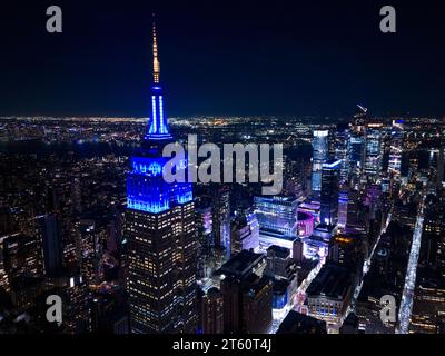 New York, NY, USA - 25 ottobre 2023: Foto aerea dell'Empire State Building illuminata di blu di notte Foto Stock