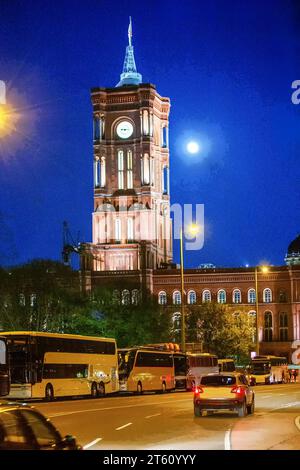 Municipio Rotes Rathaus (Torre dell'Orologio) vicino ad Alexanderplatz - stupenda vista notturna con autobus turistici nei parcheggi (forse dai Paesi Bassi) alle spalle di mo Foto Stock