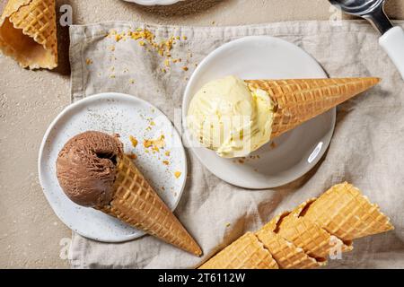 gelato al cioccolato e alla vaniglia in coni di waffle su piatti, vista dall'alto Foto Stock