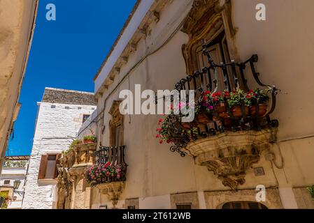 Una vista ravvicinata delle terrazze ornate delle finestre a Locorontondo, Italia in estate Foto Stock