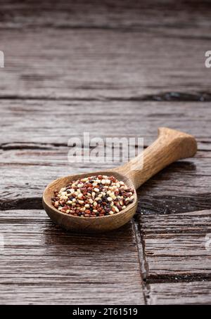 Mescolare la quinoa rossa, bianca e marrone in un cucchiaio di legno Foto Stock