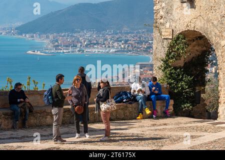 Gli escursionisti in Piazza Sant'Agostino si affacciano sulla Riviera delle Palme con sullo sfondo il porto di Loano, Borgio Verezzi, Savona, Italia Foto Stock