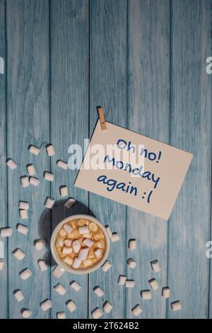 OH NO, LUNEDÌ DI NUOVO nota di testo con tazza di caffè bianco e marshmallow su sfondo di legno. Il giorno più deprimente dell'anno di gennaio. Giorno commettere suicidio e depressione segno di motivazione. Vista dall'alto, base piatta Foto Stock