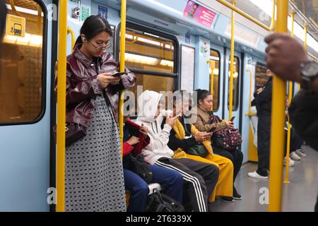 MILANO, ITALIA - 22 ottobre 2022: I passeggeri non identificati utilizzano i telefoni cellulari in metropolitana. Foto Stock