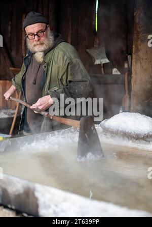 3 novembre 2023, bassa Sassonia, Lüneburg: Mimke Koch, mastro cuoco al Museo tedesco del sale, si muove attraverso la salina nella capanna bollente con un raker. Sale reso ricco Lüneburg. Ma non c'erano solo aspetti positivi nelle miniere. Foto: Philipp Schulze/dpa Foto Stock