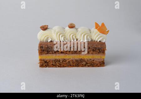 Fetta di torta di carote, torta di spugna di carota a strati su sfondo luminoso Foto Stock