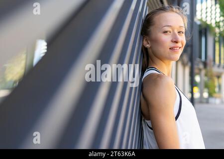 Foto di una donna attiva scattata in una canotta bianca che posa Foto Stock