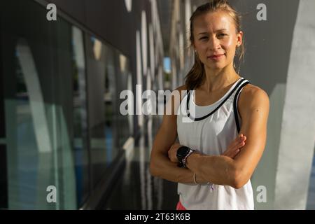 Foto di una donna attiva scattata in una canotta bianca che posa Foto Stock