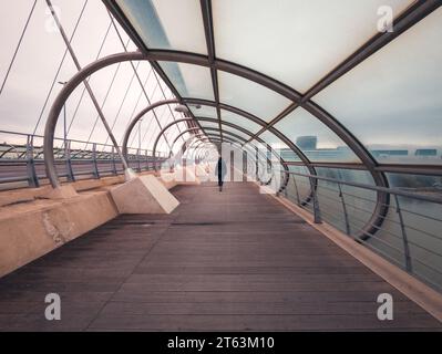 A media distanza, corpo di donna che cammina sul moderno ponte del terzo millennio a Saragozza, Spagna Foto Stock