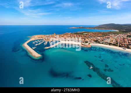 Dalla vista aerea di Castelsardo e Isola Rossa, che mostra una vivace cittadina di mare con un porticciolo lungo la costa azzurra della Sardegna, Italia Foto Stock