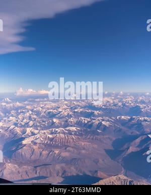 Una veduta aerea della montagne brulle della Zanskar gamma di Himalaya interno in India. Macchie nuvole monsoniche sono distribuite attraverso il paesaggio. Foto Stock