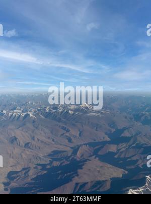 Una veduta aerea della montagne brulle della Zanskar gamma di Himalaya interno in India. Macchie nuvole monsoniche sono distribuite attraverso il paesaggio. Foto Stock