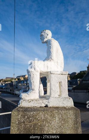 5 novembre 2023. Findochty Harbour, Moray, Scozia. Si tratta di un pescatore seduto creato nel 1959 dall'artista locale Correna Cowie. Conosciuto come White Mannie Foto Stock