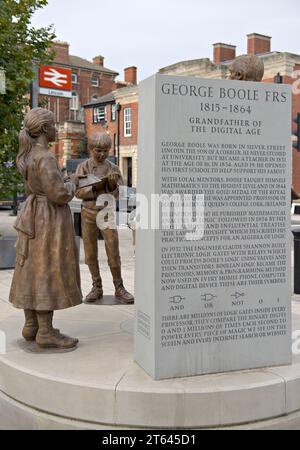 Una statua in bronzo di George Boole, matematico con studenti, situata nel piazzale della stazione ferroviaria di Lincoln, statua progettata da Antony Dufort Foto Stock