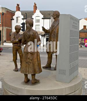 Una statua in bronzo di George Boole, matematico con studenti, situata nel piazzale della stazione ferroviaria di Lincoln, statua progettata da Antony Dufort Foto Stock