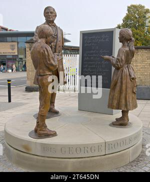 Una statua in bronzo di George Boole, matematico con studenti, situata nel piazzale della stazione ferroviaria di Lincoln, statua progettata da Antony Dufort Foto Stock