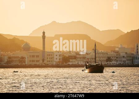 Porto con barca tradizionale in legno in sambuco e lungomare della città vecchia di Mascate. Sultanato dell'Oman. Foto Stock