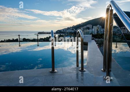 La vista al tramonto verso la città Vecchia dalla piscina a sfioro sul tetto dell'Iberostar Slavija Hotel, Budva, Budva Riviera, Montenegro Foto Stock
