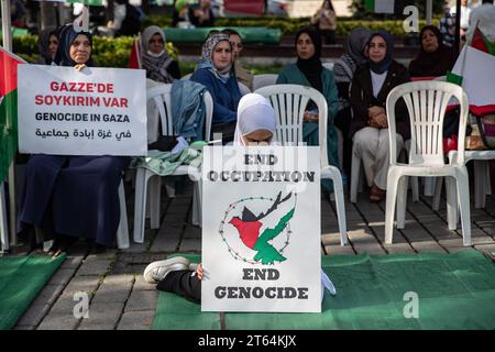Istanbul, Turchia. 8 novembre 2023. Una donna dimostrante tiene un cartello con la scritta "fine occupazione fine genocidio” durante una protesta sit-in. L'iniziativa di solidarietà con le donne palestinesi prosegue l'ottavo giorno della protesta sit-in di 15 giorni in piazza Sultanahmet. Credito: SOPA Images Limited/Alamy Live News Foto Stock
