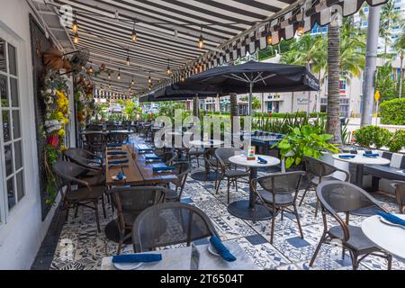 Scopri l'invitante esterno del ristorante cittadino con tavoli elegantemente allestiti pronti ad accogliere i visitatori nelle giornate luminose e soleggiate. Miami Beach. USA. Foto Stock